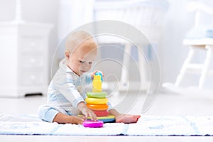 Baby playing with toy pyramid. Kids play