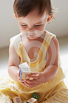 Baby, playing and toys in living room floor, building blocks and sensory growth in family home. Curious, girl or play