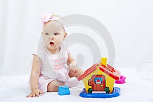 Baby is playing with toys over white background