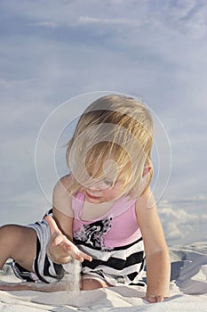 Baby playing in white sand