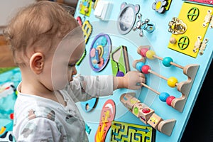 Baby playing with a wooden set of entertaining board game elements