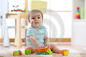 Baby playing wooden toys at home or kindergarten