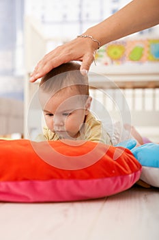 Baby on playmat concentrating