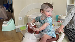 baby plays bike indoors. happy family a kid dream concept. baby girl riding a children's scooter in the room indoors