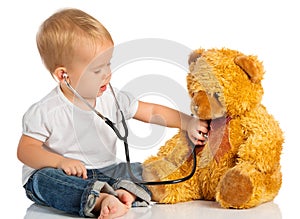 Baby plays in doctor toy bear, stethoscope photo