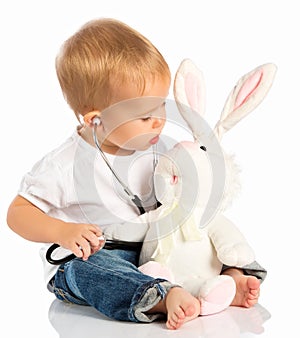 Baby plays in doctor toy bunny rabbit and stethoscope