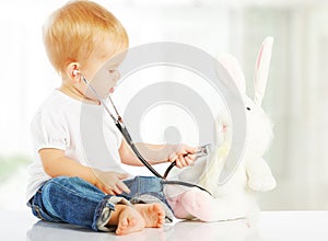 Baby plays in doctor toy bunny rabbit and stethoscope