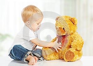 Baby plays in doctor toy teddy bear and stethoscope