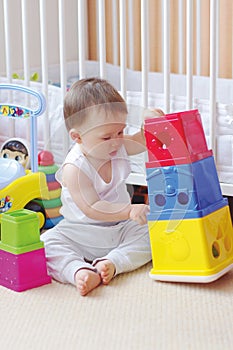 Baby plays nesting blocks at home