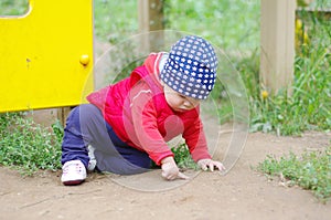 Baby points something sitting on the ground