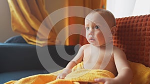 baby portrait. baby son sitting on the couch watching TV cartoons. happy family kid dream concept. baby toddler close-up