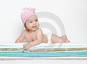 Baby portrait in diaper on towel at studio, white background