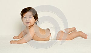 Baby portrait in diaper on white towel at studio, yellow toned