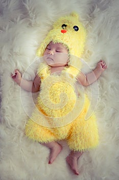 Baby portrait :Happy sleeping Asian baby wearing yellow rooster