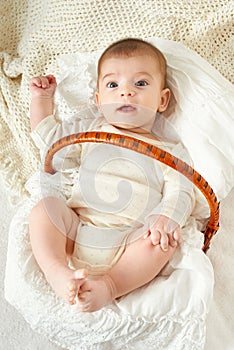 Baby portrait lie on white towel in bed, yellow toned