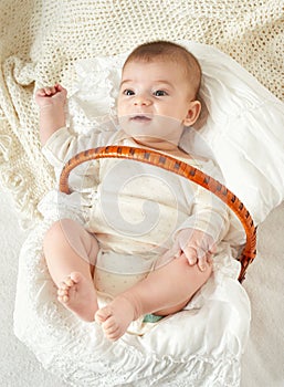 Baby portrait lie on white towel in bed, yellow toned