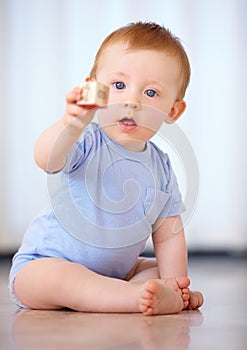 Baby, portrait and playing with wooden blocks or toys for childhood development on a gray studio background. Little boy