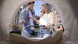 Baby pov looking at angry young parents arguing front of baby carriage, family