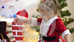 Baby and pregnan mom hang red ball toy on Christmas tree. happy childhood concept. child and mother decorate tree with