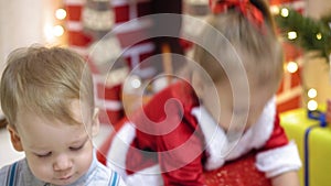 Baby and pregnan mom hang red ball toy on Christmas tree. happy childhood concept. child and mother decorate tree with