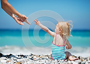 Baby pulling hands to mother
