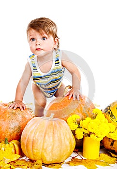 Baby among pumpkins