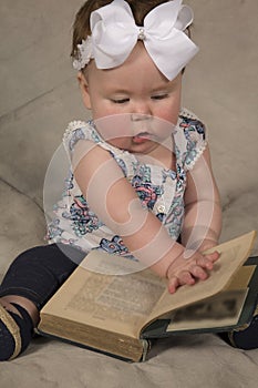 Baby reading book look down