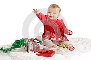 Baby in red velvet Christmas dress reaches up