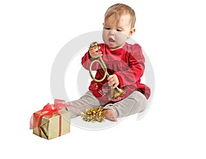 Baby in red velvet dress inspects toy horn