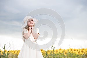 Baby rejoice to smile. beautiful girl in a white dress and a white hat.