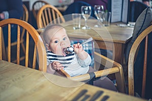 Baby in restaurant with spoon