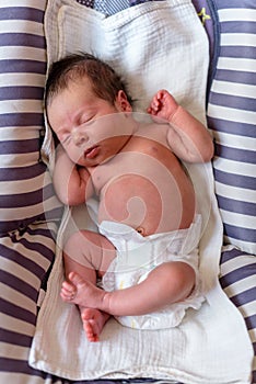 Baby resting comfortably in a diaper on a baby hammock