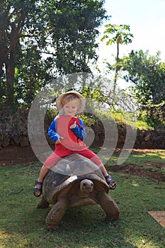 Baby riding giant turtle