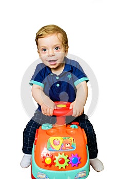 Baby riding toy car. Isolated