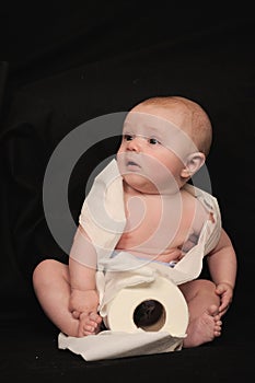 Baby with roll of toilet paper