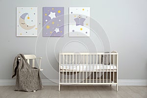 Baby room with crib and cute posters on wall