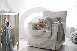 Baby room interior with crib and armchair