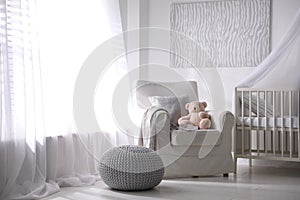 Baby room interior with crib and armchair