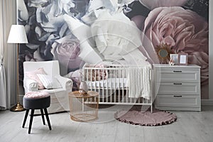 Baby room interior with crib and floral wallpaper