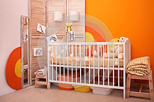Baby room interior with crib near wall