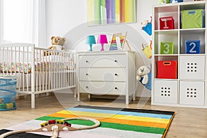 Baby room with white cradle and chest of drawers