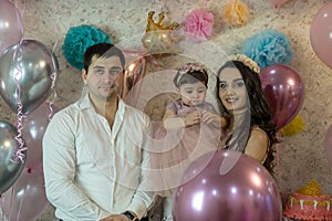 Baby`s birthday celebration.  Against the background of balloons, in pink colors.