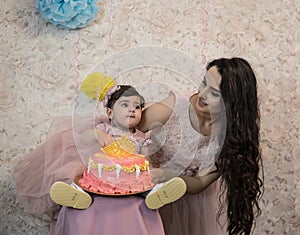 Baby`s birthday celebration.  Against the background of balloons, in pink colors.