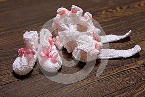 baby's bootee and cap on wooden