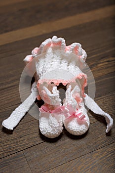 Baby's bootee and cap on wooden