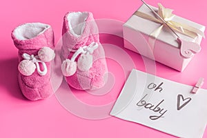 Baby`s bootees and gift box on wooden background