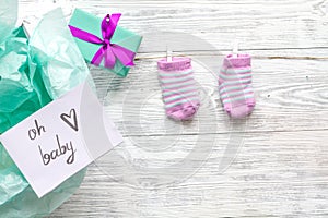 Baby`s bootees and gift box on wooden background