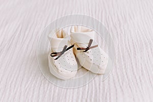 Baby`s boots on white background. Waiting for baby. white shoes for newborn on a pastel blue background.