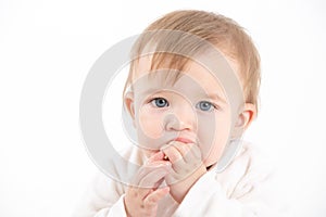 Baby\'s face with fingers in the mouth