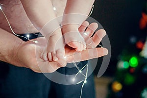 Baby`s feet in a man`s hand Christmas